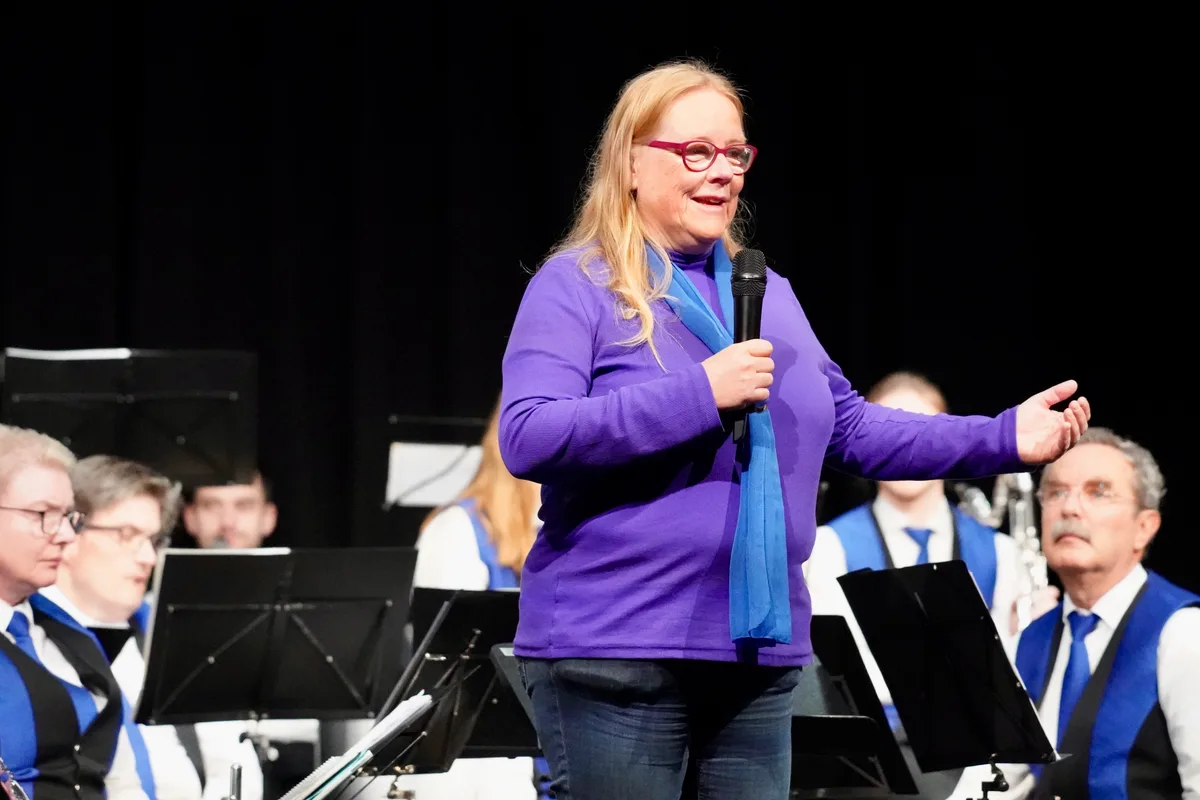 Auch die Stiftungsratspräsidentin der Oberen Mühle, Andrea Kennel, wandte sich ans Publikum. Eine Frau in einem violetten Pullover steht auf einer Bühne.
